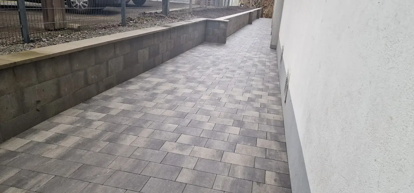 Gepflasterte Terrasse mit Mauer nach Regen