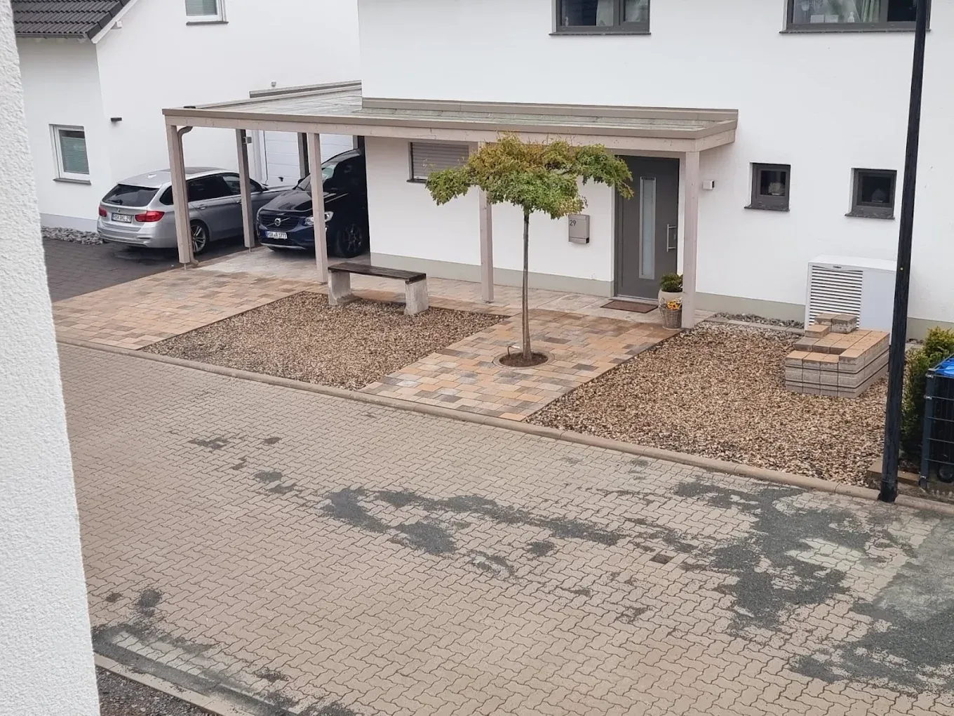 Nachher: Fertiger Vorgarten mit Pflaster, Kiesflächen und Carport